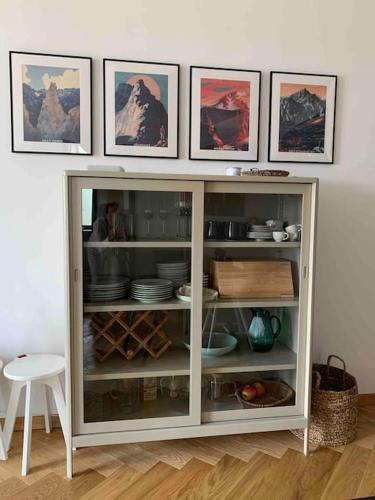 a white cabinet with plates and dishes in it at BOTKa apartmán, Tatranská Štrba in Tatranska Strba