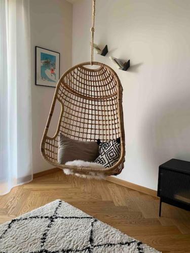 a hanging rattan chair in a living room at BOTKa apartmán, Tatranská Štrba in Tatranska Strba