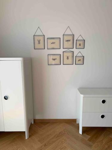 a room with a white wall with pictures on the wall at BOTKa apartmán, Tatranská Štrba in Tatranska Strba