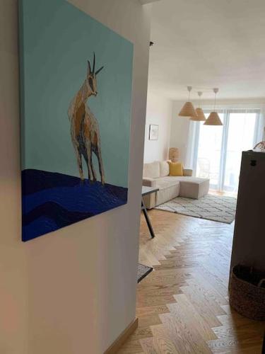a living room with a painting of a giraffe on the wall at BOTKa apartmán, Tatranská Štrba in Tatranska Strba