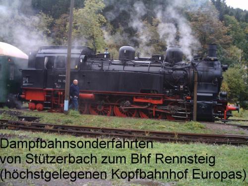 a man standing next to a black train on the tracks at Gasthof 'Zum Reifberg' in Ilmenau