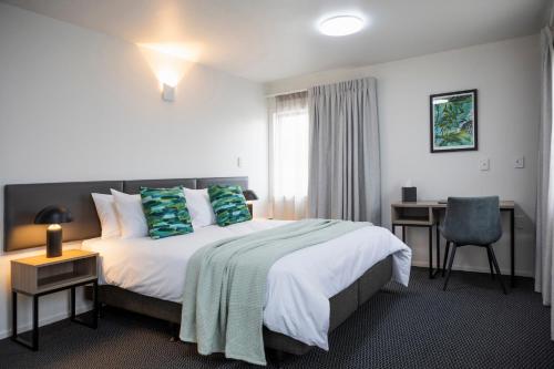 a hotel room with a bed and a desk at Solsen Flexi-Stay in Auckland