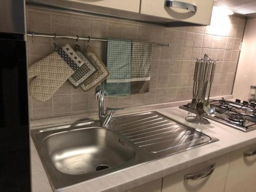 un fregadero de acero inoxidable en una cocina junto a una estufa en Da Zio Ciro a Capodimonte, en Nápoles