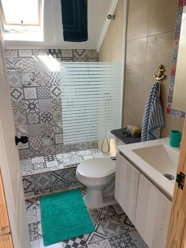a bathroom with a white toilet and a sink at Familiar 2 Rocas del Mar in Pichilemu