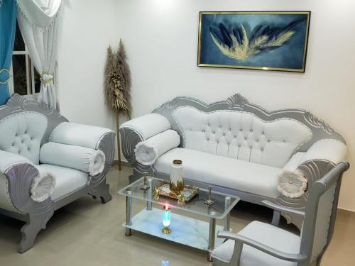 ein Wohnzimmer mit 2 weißen Sofas und einem Tisch in der Unterkunft Hermoso Apartamento En Cerro Alto Santiago in Santiago de los Caballeros
