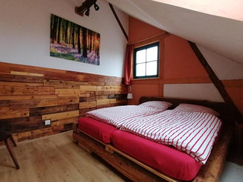 um quarto com uma cama com uma parede em madeira em Ferienwohnung Villa Claudia em Dresden