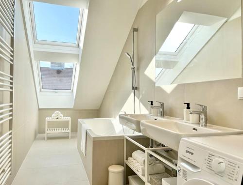 a bathroom with two sinks and a skylight at OrestaLiving - Penthouse in 1020 in Vienna