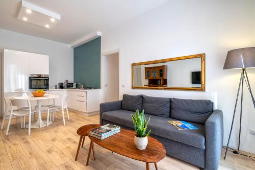 a living room with a blue couch and a table at RelaisApartments MERCEDE - Extraordinary Hospitality in Alghero