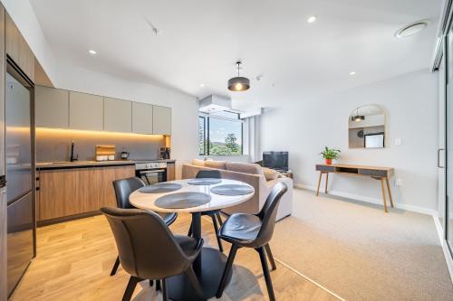 a kitchen and a living room with a table and chairs at Hutt Central in Lower Hutt