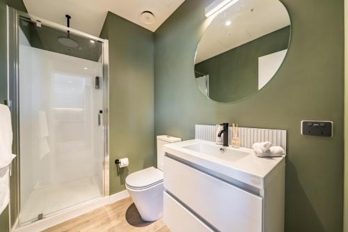 a bathroom with a toilet and a sink and a mirror at Hutt Central in Lower Hutt