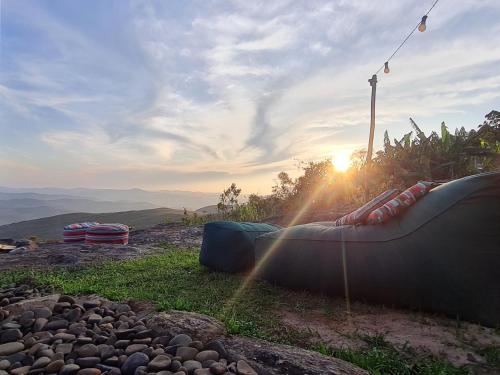 a view of the sun setting on a hill with rocks at Estúdio Amor: refúgio à dois nas montanhas in Lavras Novas