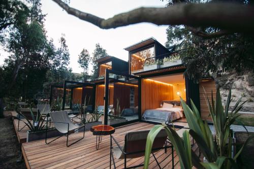 a house with a bed and chairs on a deck at Hawkay Glamping in San Miguel de Salcedo