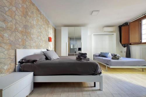a bedroom with two beds and a stone wall at Vatican Flat Spacious Cozy with Court in Rome
