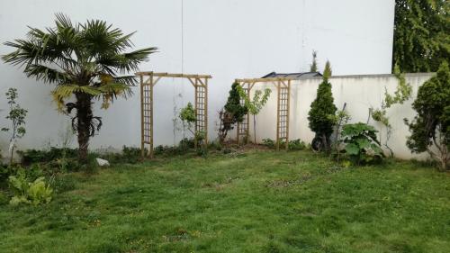 a yard with a fence and a palm tree at 3 private rooms shared flat in a villa at Sceaux 600m RER B direct to Notre-Dame in Sceaux