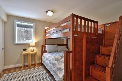 ein Schlafzimmer mit einem Etagenbett mit einer Leiter in der Unterkunft Premium 5 bedroom, pet friendly private home with hot tub 3 miles from the Skyship Bear in Killington