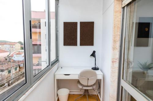 - un bureau et une chaise dans une chambre avec fenêtres dans l'établissement AL Cacém, à Paiõis