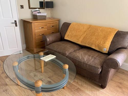 a living room with a couch and a glass table at Walkers Rest! in Alfriston