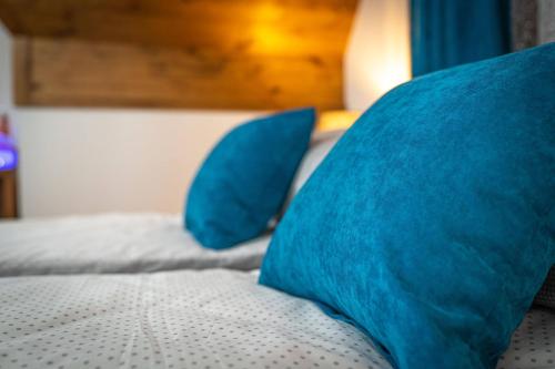 a bed with two blue pillows on top of it at Domki Bukowianka in Murzasichle