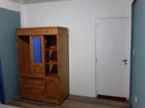 un armario de madera en una habitación con puerta en daniela en Santa Teresita