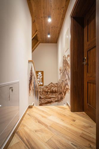 a hallway with a wooden door and a painting on the wall at Domki Bukowianka in Murzasichle