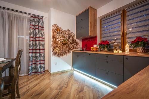 a kitchen with a counter and a table in a room at Domki Bukowianka in Murzasichle