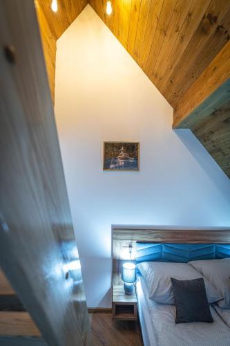 a bedroom with a bed and a wooden ceiling at Domki Bukowianka in Murzasichle