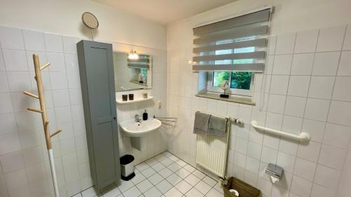 a bathroom with a sink and a toilet and a window at Ferienwohnung Südhoff in Horumersiel