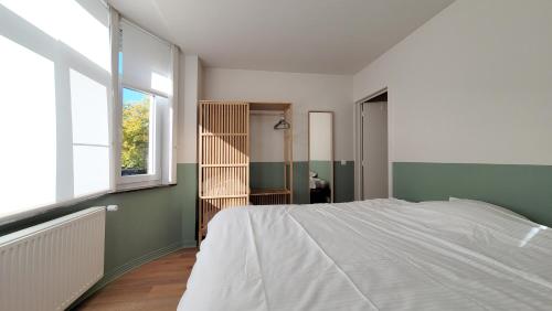 een slaapkamer met een wit bed en een raam bij oYo apartments in Kortrijk