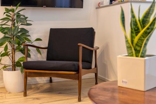a black chair in a room with plants at RelaisApartments PORTO in Alghero
