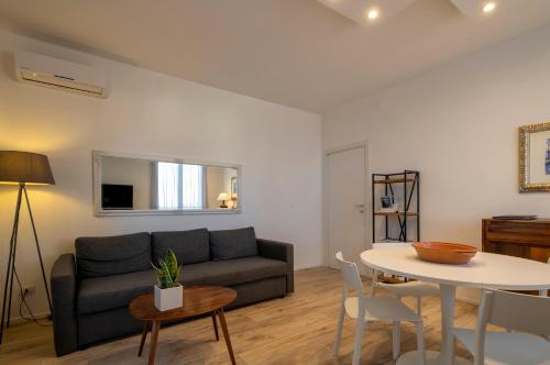 a living room with a couch and a table at RelaisApartments PORTO in Alghero