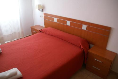 a bedroom with a red bed with a wooden headboard at Hotel Sierra Mar in La Unión