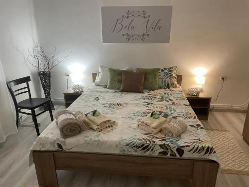 a bedroom with a large bed with towels on it at Bela Vila in Negotin