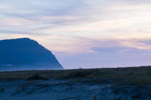 a mountain in the middle of a field at sunset at Inn of the Four Winds Seaside Oceanfront in Seaside
