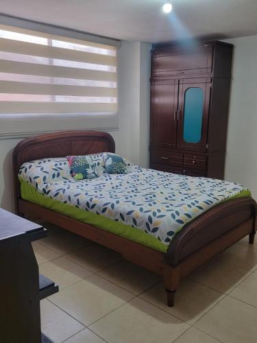 1 dormitorio con 1 cama con tocador y ventana en Habitación a estrenar con baño privado, sector jipijapa, en Quito