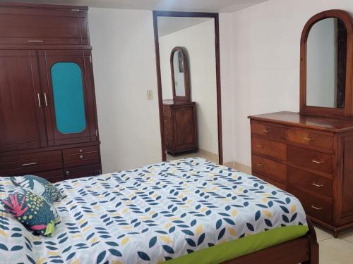 1 dormitorio con cama, tocador y espejo en Habitación a estrenar con baño privado, sector jipijapa, en Quito