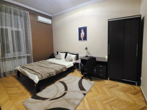 a bedroom with a bed and a desk and a window at В центрі м.Чернівці 2 кімнатна затишна квартира. in Chernivtsi