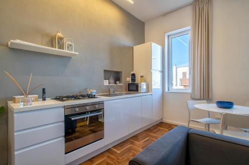 a kitchen with a stove and a counter top at RelaisApartments PORTO in Alghero