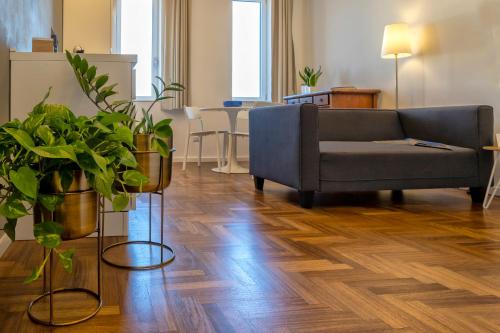 a living room with a couch and potted plants at RelaisApartments PORTO in Alghero