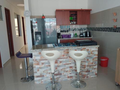 una cucina con 2 sgabelli e bancone di Amplia y bella casa de vacaciones a Flandes