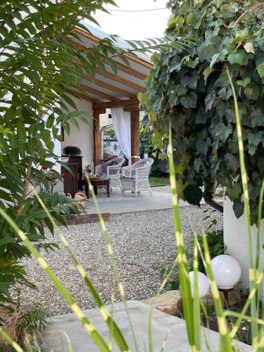 a patio with a table and chairs in a garden at Bela Vila in Negotin
