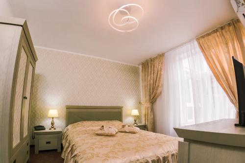 - une chambre avec un lit et un lustre dans l'établissement HOTEL CORA Bistrita, à Bistriţa