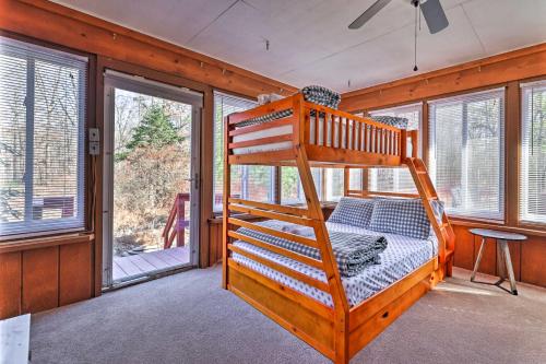 a bedroom with a bunk bed in a room with windows at Pocono Mountains Cabin with Patio, Near Hiking! in East Stroudsburg