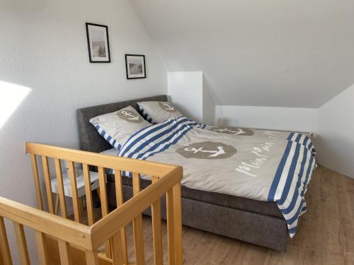 a small bedroom with a bed and a crib at Villa Seewind "Pier 15" in Dahme