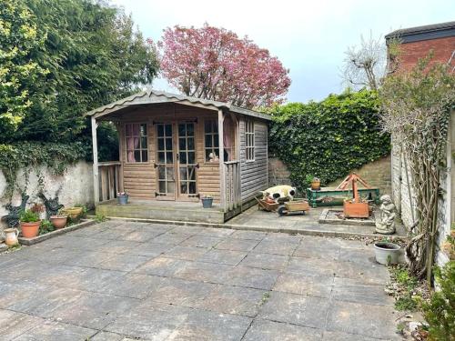 a small wooden shed with a dog in a yard at The Cottage, a perfect getaway! in Southport
