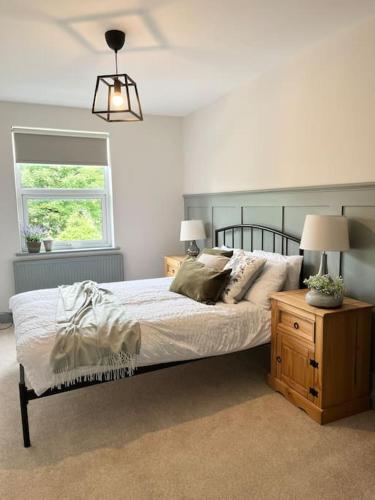 um quarto com uma cama, um candeeiro e uma janela em The Cottage, a perfect getaway! em Southport