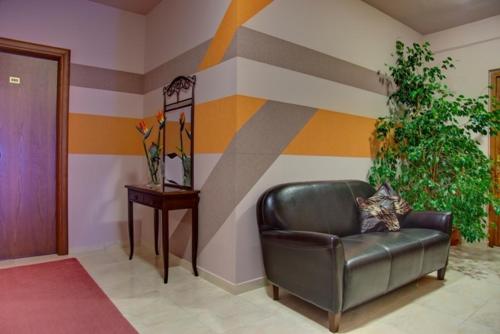 a leather couch in a room with a striped wall at Dryades Hotel in Naousa Imathias