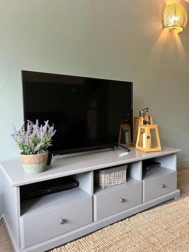 a white entertainment center with a flat screen tv on it at The Cottage, a perfect getaway! in Southport