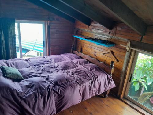Bett in einem Zimmer mit einer Holzwand in der Unterkunft Bunker Hostel in Cabo Polonio