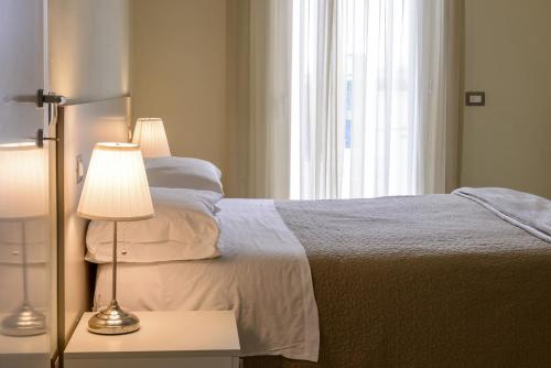 a bedroom with a bed with a lamp and a window at Residence Millecento in Cesenatico