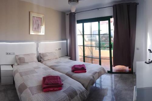 a bedroom with two beds with red towels on them at Premium Duplex Castillo Mar 32 in Caleta De Fuste